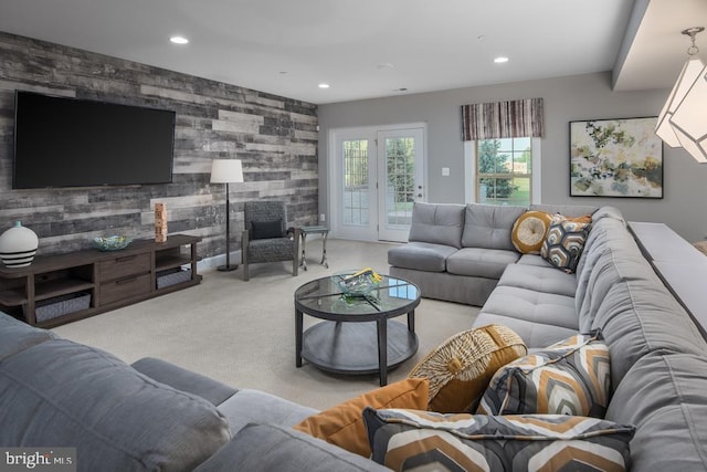 living room with light carpet and wood walls