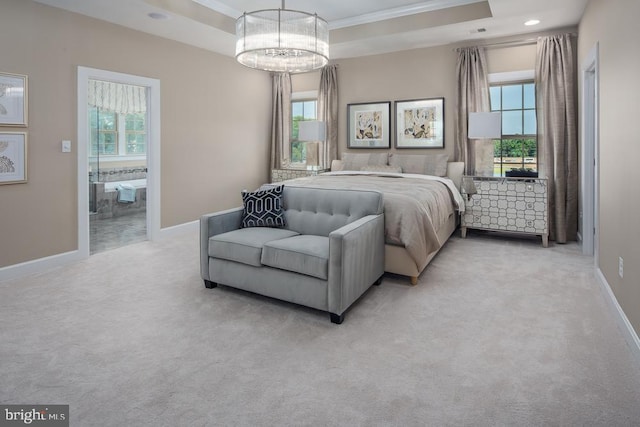 carpeted bedroom with ensuite bath, ornamental molding, a raised ceiling, and multiple windows