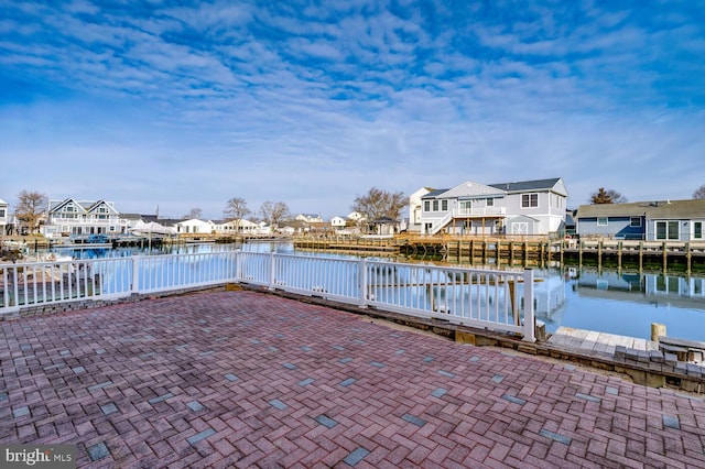 view of dock with a water view and a patio area