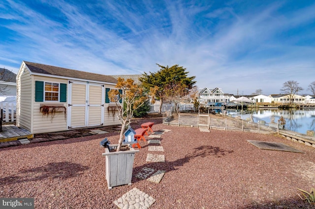 rear view of property with a storage unit and a water view