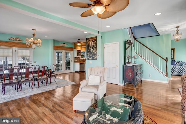 living room featuring wood-type flooring, an inviting chandelier, and french doors