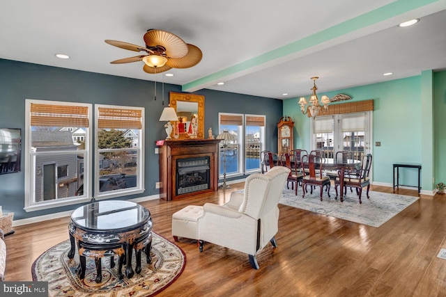 living room with hardwood / wood-style flooring, beamed ceiling, and a notable chandelier