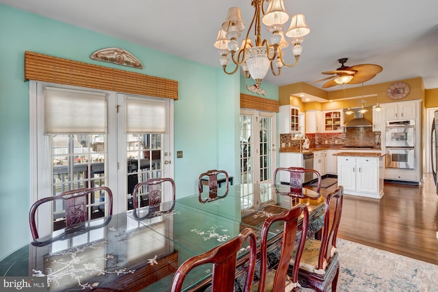 dining room featuring dark hardwood / wood-style flooring, sink, and ceiling fan with notable chandelier