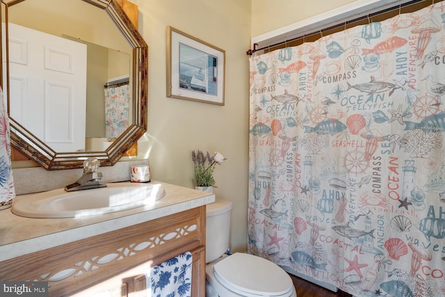 bathroom with vanity, curtained shower, and toilet