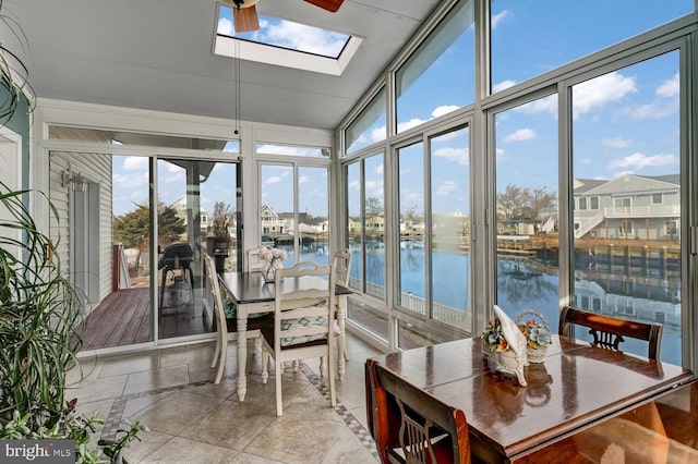 sunroom featuring a water view, a healthy amount of sunlight, and a skylight