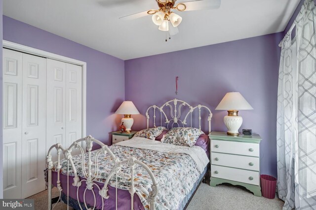 carpeted bedroom with ceiling fan and a closet