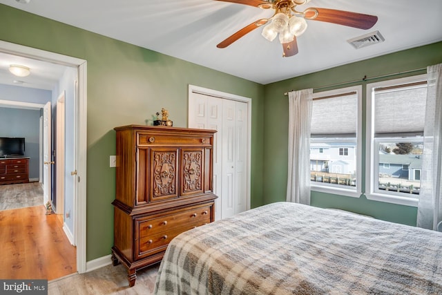 bedroom featuring light hardwood / wood-style flooring, a closet, and ceiling fan