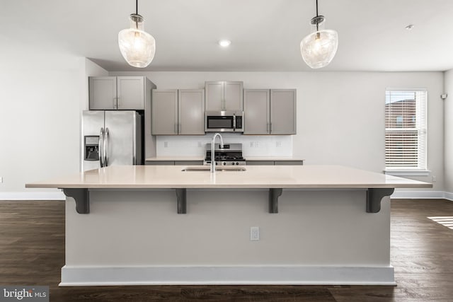 kitchen featuring hanging light fixtures, appliances with stainless steel finishes, a large island, and gray cabinetry