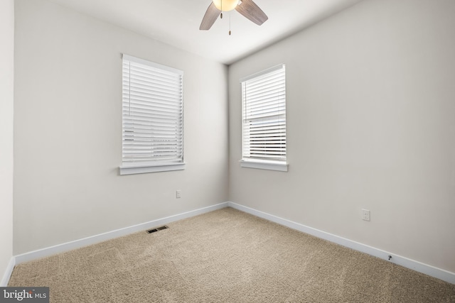 carpeted spare room featuring ceiling fan