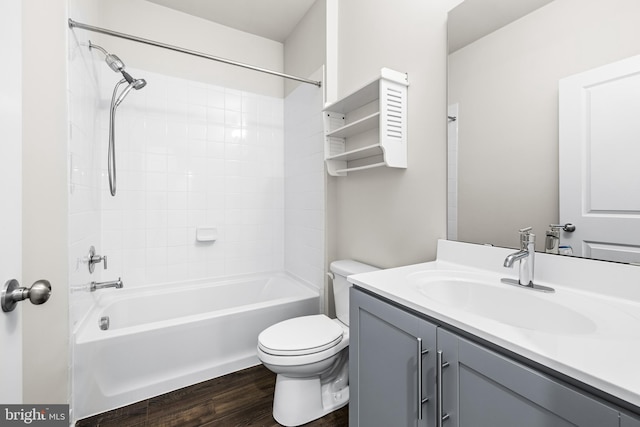 full bathroom with tiled shower / bath combo, vanity, hardwood / wood-style floors, and toilet