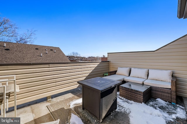 snow covered patio with an outdoor living space