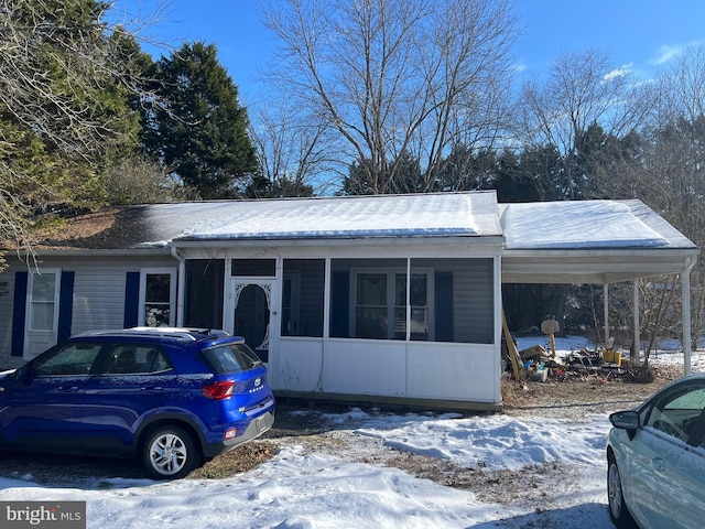 view of front of house featuring a sunroom and a carport