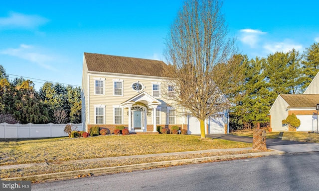 colonial-style house with a garage and a front yard