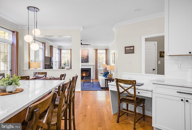 dining room featuring crown molding and light hardwood / wood-style flooring