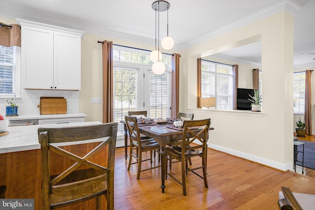 dining room featuring ornamental molding, a healthy amount of sunlight, and light wood-type flooring