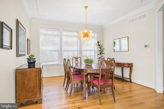 dining area featuring ornamental molding, a chandelier, and light wood-type flooring