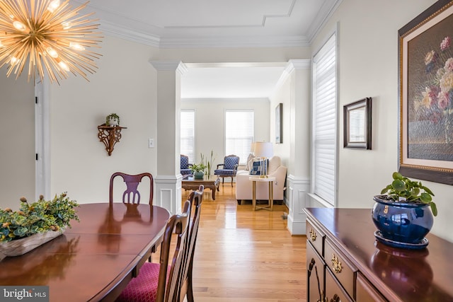 dining space with ornamental molding, decorative columns, light hardwood / wood-style flooring, and a notable chandelier