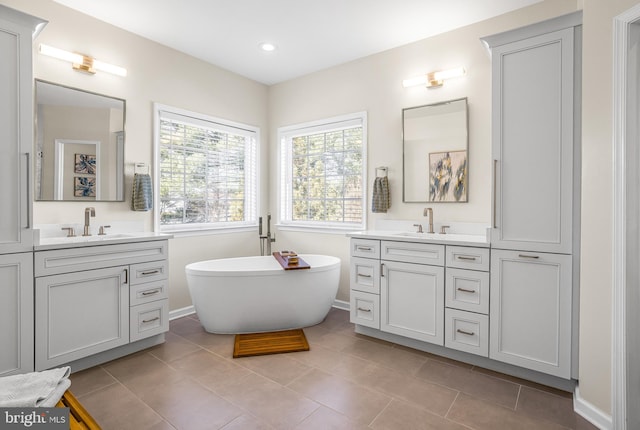 bathroom with tile patterned flooring, vanity, and a tub to relax in