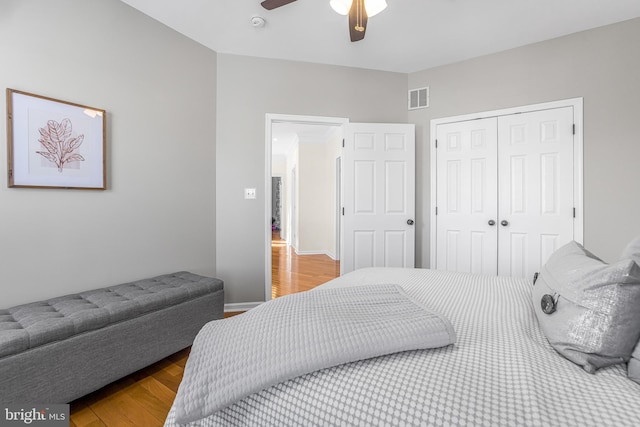 bedroom with wood-type flooring, ceiling fan, and a closet