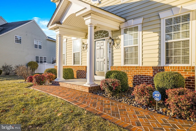 entrance to property with a yard and covered porch