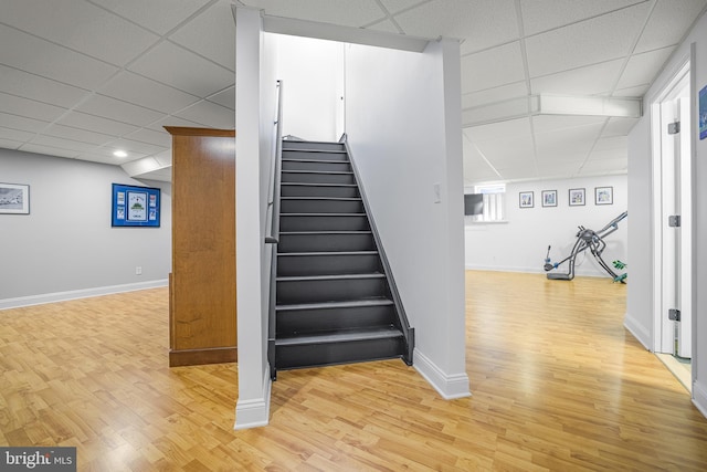 stairs featuring hardwood / wood-style floors and a paneled ceiling