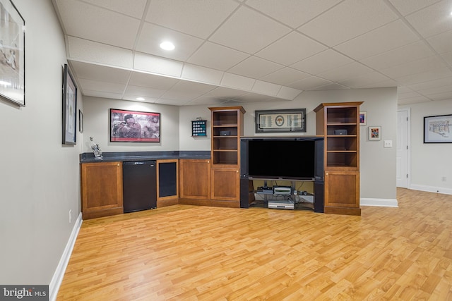 unfurnished living room featuring a drop ceiling and light hardwood / wood-style floors