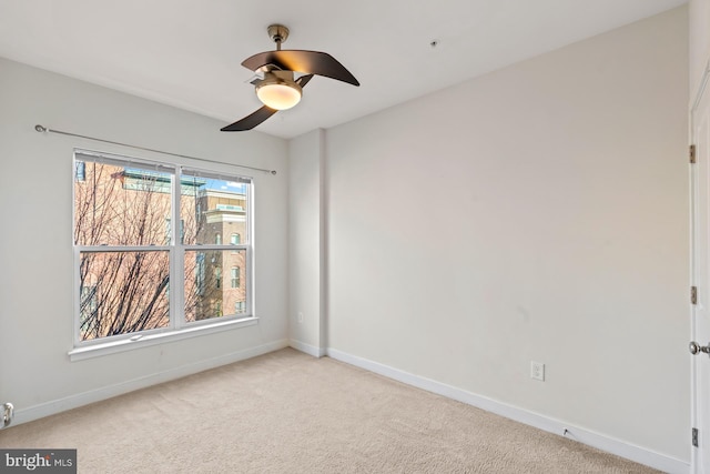 spare room with light colored carpet and ceiling fan