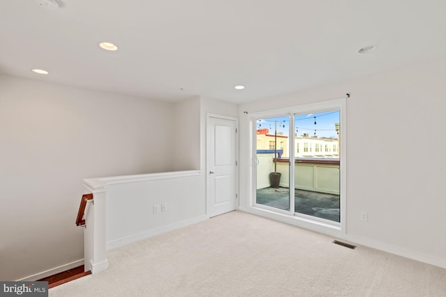 unfurnished room featuring light colored carpet