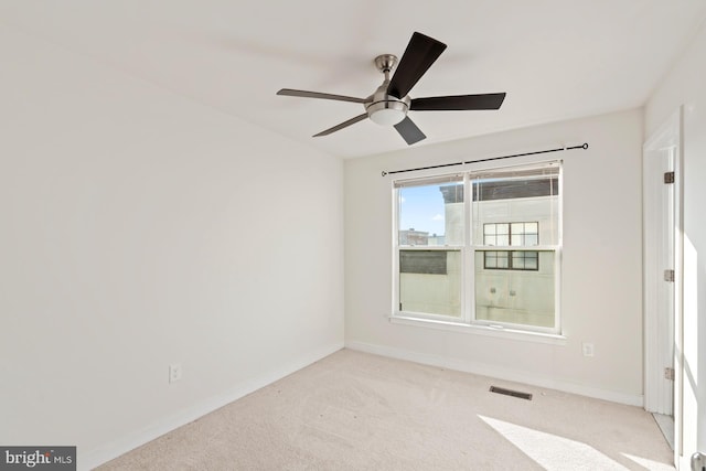 carpeted spare room featuring ceiling fan