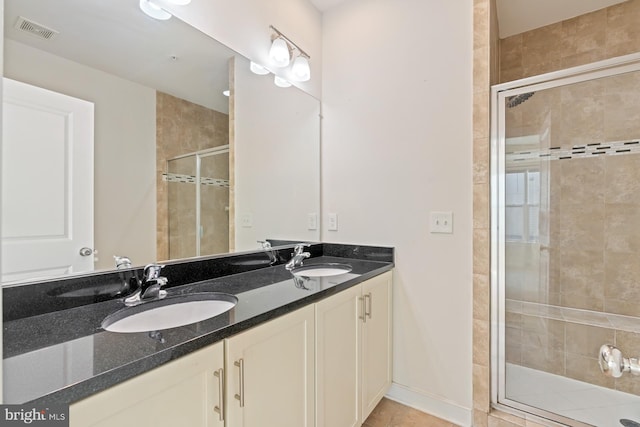 bathroom featuring vanity, tile patterned floors, and a shower with shower door