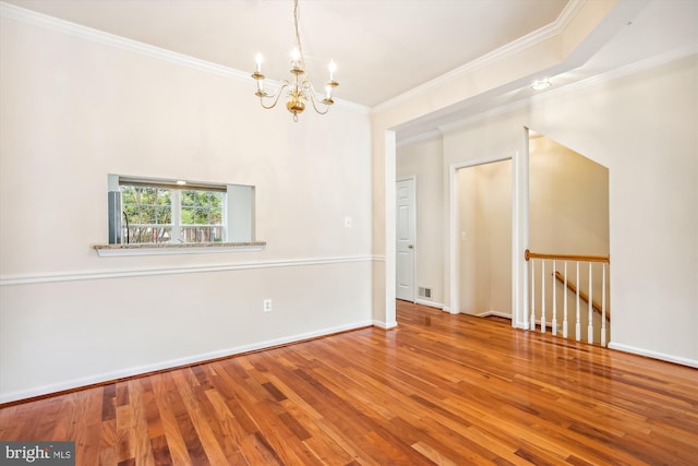 unfurnished room featuring wood-type flooring, ornamental molding, and a chandelier