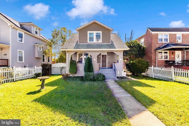 bungalow with roof with shingles, fence private yard, and a front yard