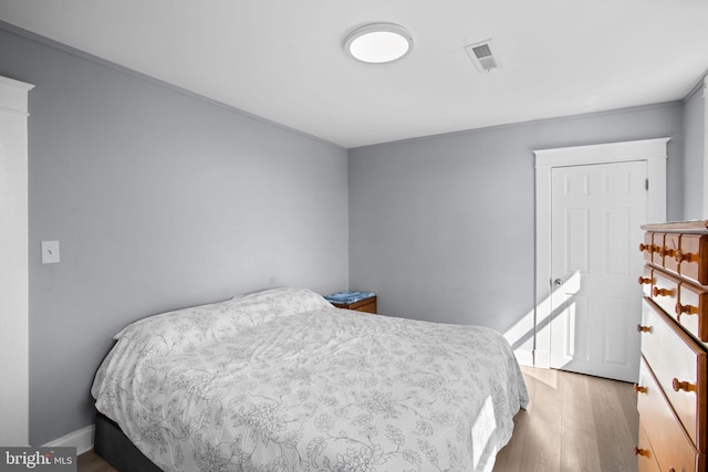 bedroom featuring wood finished floors, visible vents, and baseboards