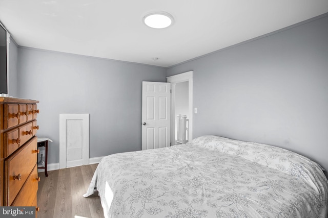 bedroom with wood finished floors and baseboards