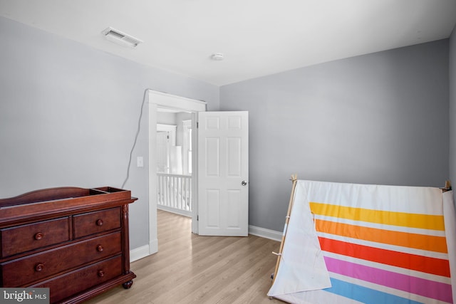 bedroom with light wood-style flooring, baseboards, and visible vents