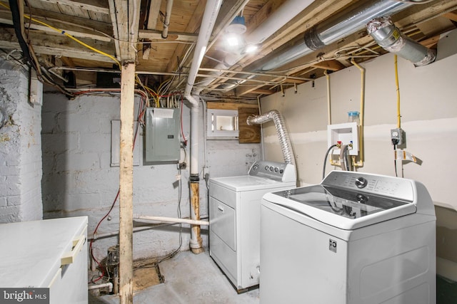 clothes washing area with electric panel, separate washer and dryer, and laundry area