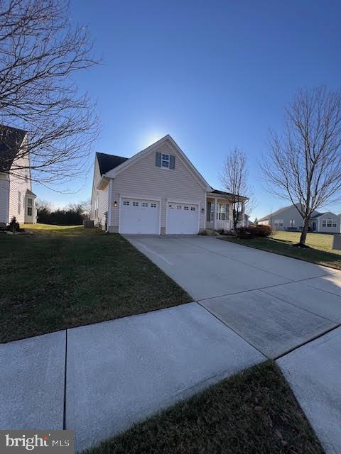 view of property exterior with a garage, a lawn, and concrete driveway