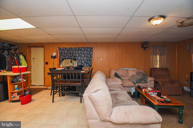 living room featuring wooden walls and a drop ceiling