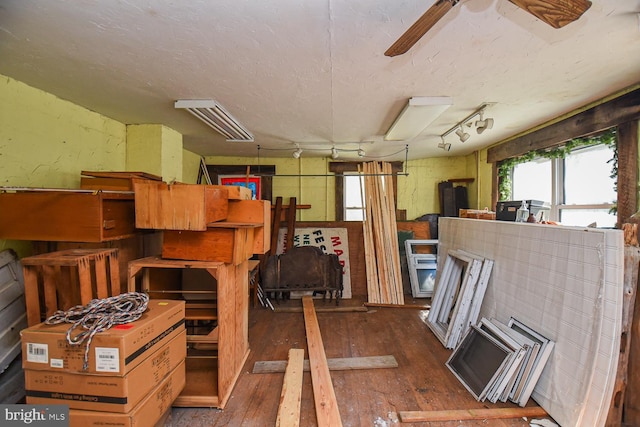 miscellaneous room with dark wood-type flooring, a textured ceiling, and track lighting