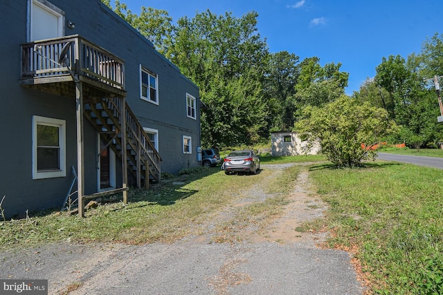 view of side of home featuring a wooden deck and a yard