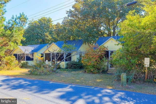 obstructed view of property with a front lawn