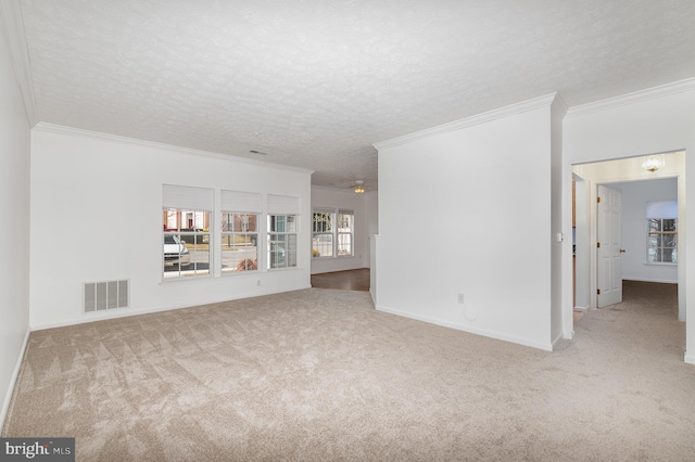 unfurnished living room with light colored carpet, ornamental molding, and a textured ceiling