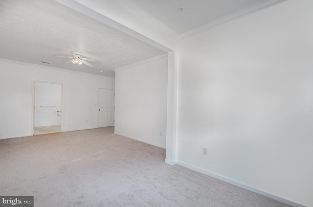 empty room featuring crown molding, light colored carpet, and ceiling fan