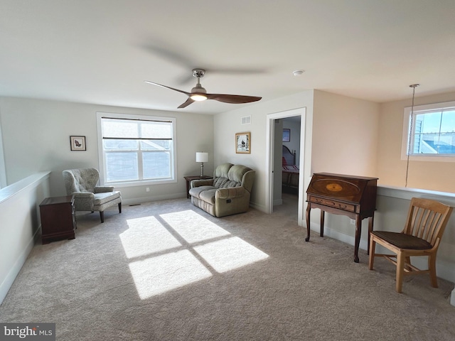 sitting room with ceiling fan and light colored carpet