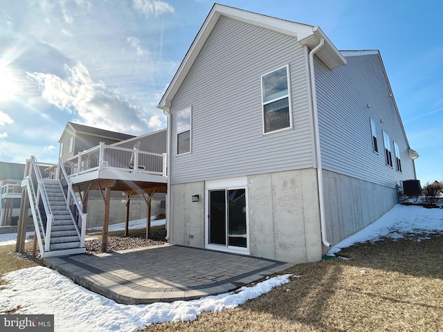 rear view of house featuring a deck and a patio area