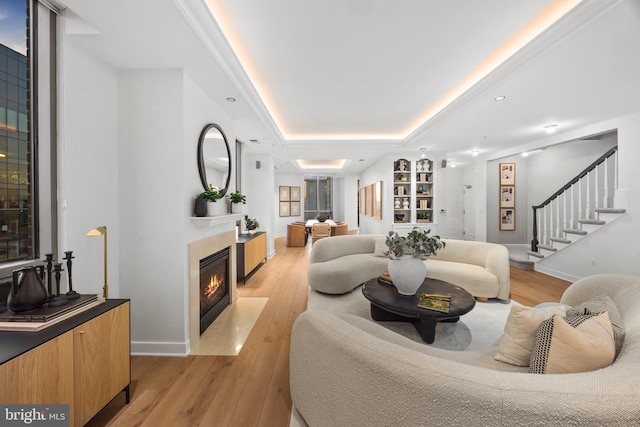 living room featuring a tray ceiling and light hardwood / wood-style floors