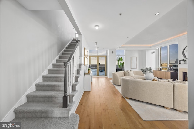 living room with a raised ceiling and light wood-type flooring