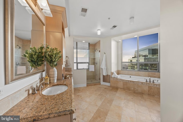 bathroom featuring vanity, plus walk in shower, and a healthy amount of sunlight