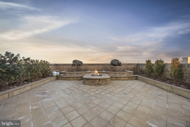 patio terrace at dusk featuring an outdoor fire pit