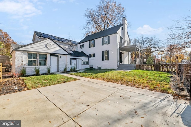 view of front of property with a balcony and a front lawn